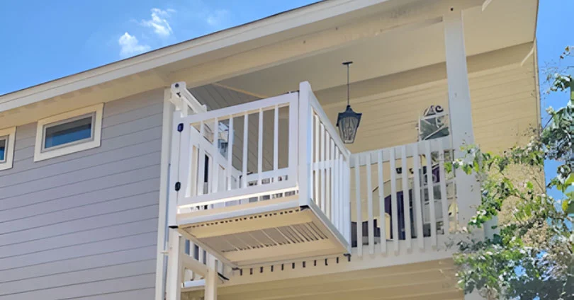 shut bolt together White home elevator with railing connects two levels of a house, enhancing accessibility under a blue sky.
