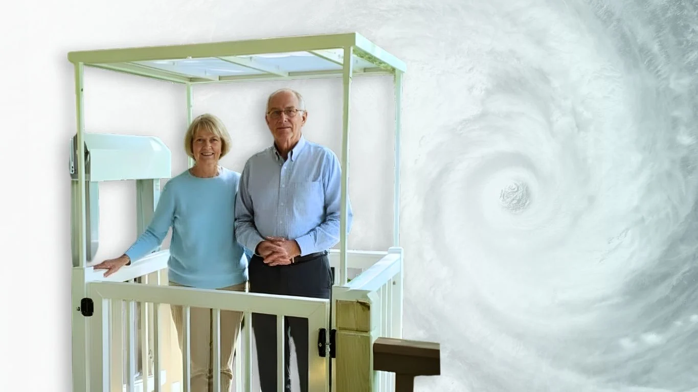 Planning Accessibility Improvements Before Hurricane Season Elderly couple stands on home elevator platform, smiling against a swirling hurricane backdrop.